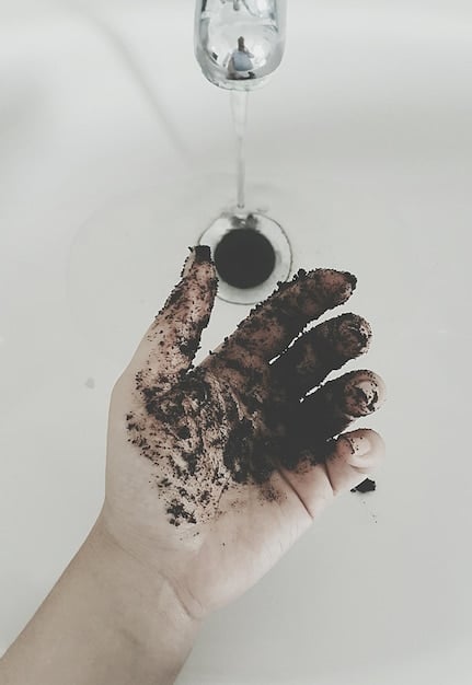 A person's gloved hand turning a compost pile with a pitchfork, steam gently rising, indicating healthy microbial activity and heat generation. The compost looks dark and rich.