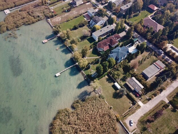 An aerial view of a US coastal town, showing homes closely built to the shoreline, with water levels perceptibly higher than historical norms, signifying increased flood risk.