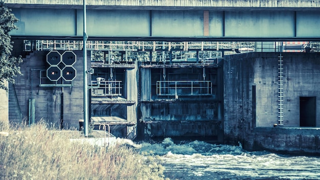 A flooded electrical substation with water levels reaching equipment, showing damaged control panels and submerged transformers, illustrating the vulnerability of energy infrastructure.