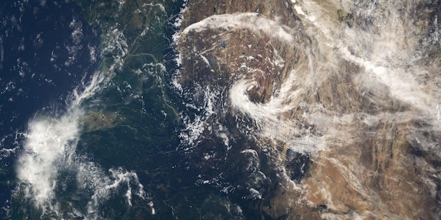 A satellite view of a powerful hurricane swirling over the Atlantic Ocean approaching the US coastline, with detailed weather icons illustrating wind and rain.