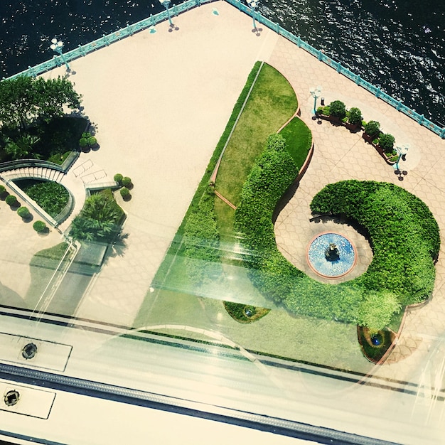 An architectural blueprint of a coastal development showcasing nature-based solutions like permeable pavements, green roofs, and elevated structures, surrounded by native vegetation.